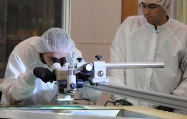 two ODU physics student work in clean room