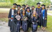 Graduates pose on campus